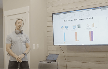 Person presenting data science tool comparison on a screen.